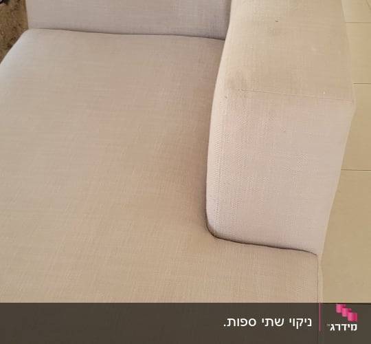 ספה בהירה עם כתמים קלים על המשענת
